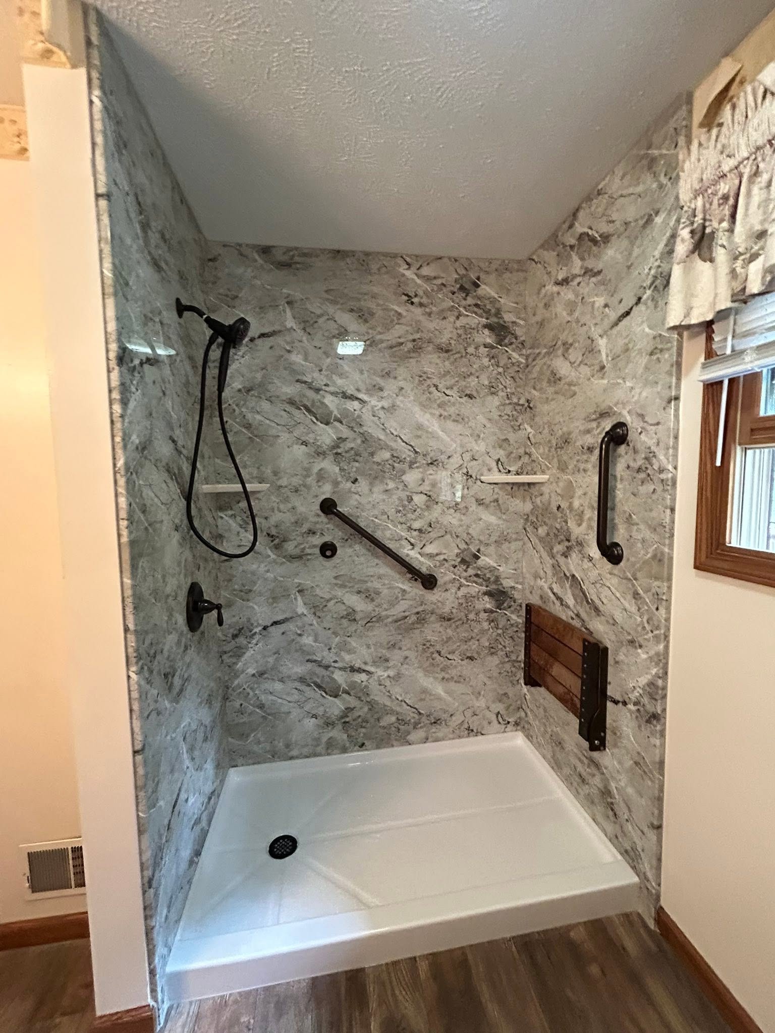 New walk-in shower with engineered-stone walls